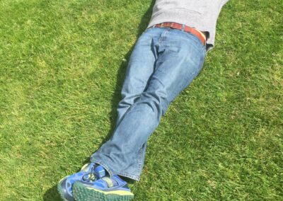 Photo of Danan Coleman laying down in grass of Greenwich Park in London, England - Photograph by Adventure With Danan
