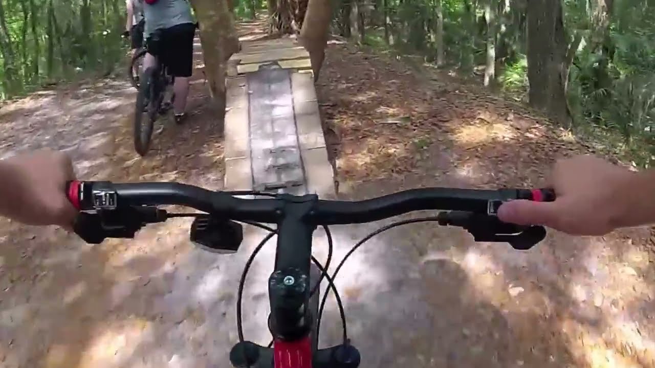 Mountain Biking North Creek at Alafia River State Park 2 A mountain biker riding ahead past a raised wooden ramp on the North Creek trail at Alafia River State Park, Florida