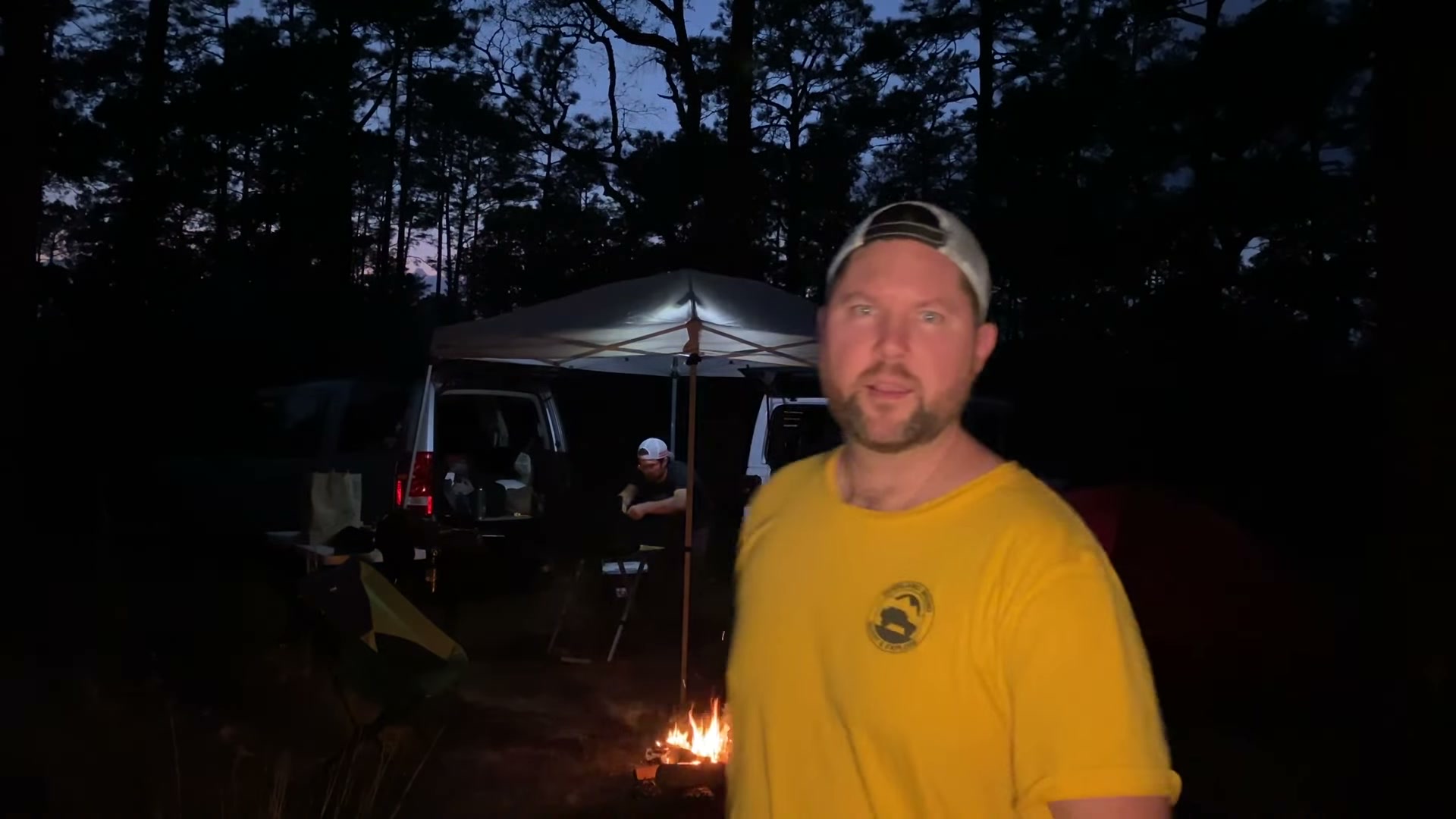 One Night in Ocala National Forest: Camp Cooking, Car Camping and Lake Dorr 2 Danan at camp at dusk in Ocala National Forest with the canopy, campfire and rigs behind him
