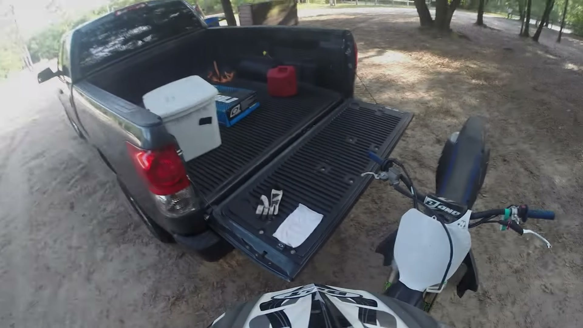 Dirt Biking the Croom Motorcycle Area 2 A pickup truck with the tailgate down, a cooler and gas can in the bed, and a dirt bike parked beside it at the Croom staging area