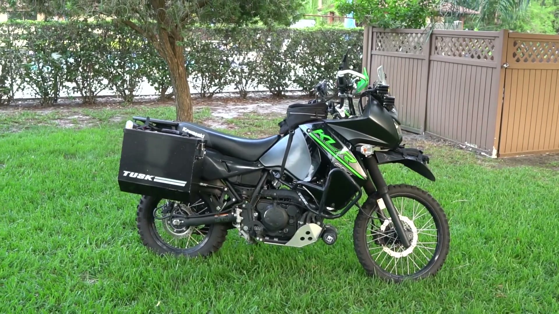 My Kawasaki KLR 650 Adventure Bike Build for the Trans America Trail 1 A fully built 2017 Kawasaki KLR 650 adventure bike in side profile on a green lawn with Tusk panniers and a skid plate