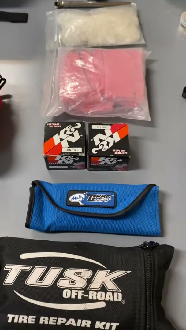 Packing a Motorcycle for a 30-Day Adventure Ride 2 Spare oil filters, a tool roll and a tire repair kit laid out for a month-long motorcycle trip